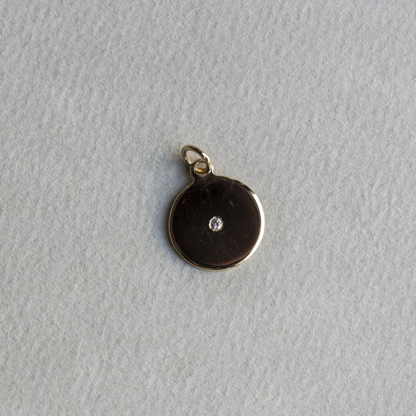 felt's own design - incredibly simple and enchanting polished gold disc with diamond